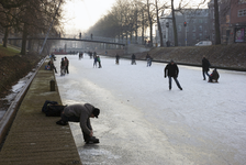 900011 Afbeelding van schaatsers op de bevroren Stadsbuitengracht te Utrecht, met op de achtergrond de St. Martinusbrug.